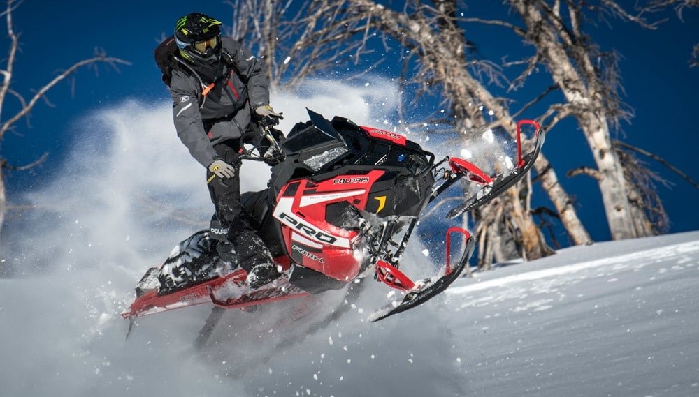 image d'un homme en habis sportif sur sa polaris rouge