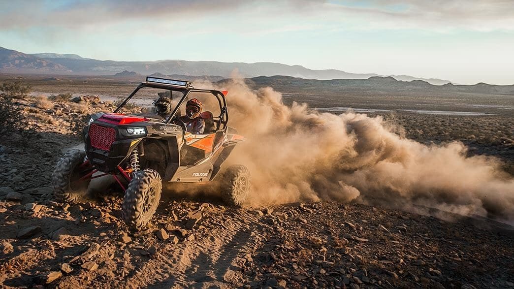 image of two persons driving their red RZR XP Dynamix side by side